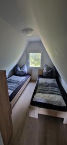 a room with two beds and a window at Ferienhaus am Helenesee 14 in Frankfurt Oder