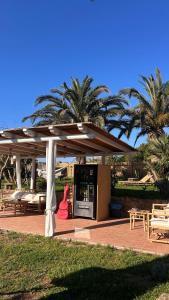 a patio with an umbrella and tables and palm trees at Calanave 10 in Ventotene