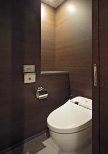 W łazience znajduje się biała toaleta i lustro. w obiekcie Akasaka Granbell Hotel w Tokio