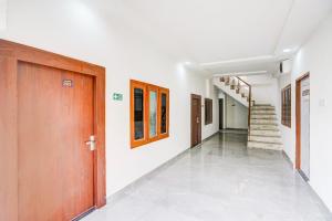 a hallway with a wooden door and stairs at Super Collection O Ashiyana formerly Rajshree in Lucknow