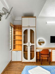 a bedroom with a white cabinet and a desk at Minh Đức Hotel Quan Lạn - Thứ 7 chỉ nhận 3 phòng trở lên in Quan Lạn