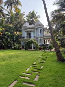 a house with a palm tree in front of it at Sea Breeze, Guhagar in Guhagar