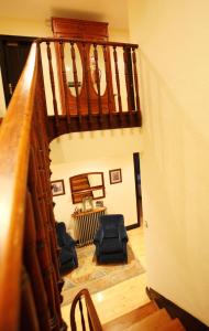 a hallway with a staircase with chairs in a house at Hotel Casa de Indianos Don Tomás in Nueva de Llanes