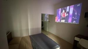 a bedroom with a bed and a tv on the wall at Era Apartment Chua Ha in Hanoi