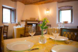 a table with plates and glasses and a vase with flowers at Agriturismo Cocò in Lamporecchio