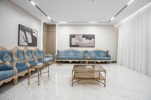 - une salle d'attente avec des canapés bleus et une table dans l'établissement شاليهات ومنتجعات ارجان بارك, à Riyad