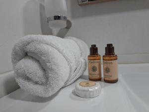 un asciugamano su un bancone accanto a due bottiglie di sapone di Shade Suites & Studios a Beirut