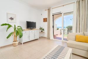 トロクス・コスタにあるFrontline Vacation Home A86 3のリビングルーム(テレビ、ソファ付)