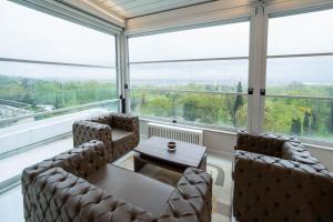 a room with a table and chairs and large windows at Golden Pars Hotel in Bursa