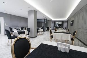 a restaurant with white tables and chairs and tablesearcher at Golden Pars Hotel in Bursa