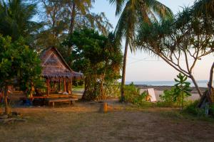 eine Hütte am Strand mit Palmen und dem Meer in der Unterkunft Lanta Coral Beach Resort in Ko Lanta