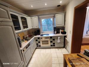 a small kitchen with white cabinets and a window at Chalets in nature Nedderhagen in Damshagen