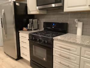 a kitchen with a black stove and a refrigerator at Deer's Meadow in Point Arena