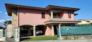 une maison rose avec un portail et une clôture dans l'établissement Villa Lago 5, à Sirmione