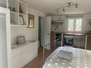 a small kitchen with a bed in a room at retreat studio in Santa Eularia des Riu