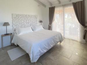 a white bed in a bedroom with a large window at Sea Love in Olbia +35 photos
