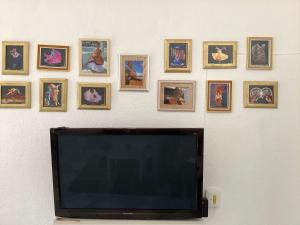 a flat screen tv hanging on a wall with pictures at Entire accommodation Departamento Mi Mexico in Mexico City