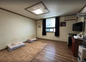 a living room with two dog beds and a window at Sangmu Green Hotel in Gwangju