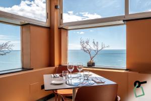 a table with wine glasses in front of a window at Hotiday Arenzano Pineta in Arenzano