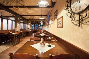 a restaurant with tables and chairs and a clock on the wall at Hotel SAMARIN Črnomelj in Črnomelj