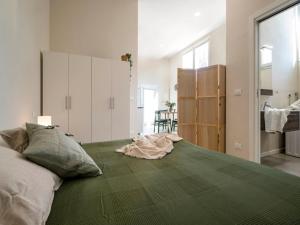 una camera da letto con un letto grande con una coperta verde di Charming Guest Room in Frassino with Private Entrance a San Giovanni in Bosco