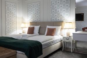 Un dormitorio con una cama grande con dos lámparas encima. en HerMira House, en Sibiu 90 fotos más