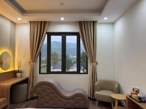 a room with a window and a chair and a couch at Kieu Anh Hotel Phu Tho in Thanh Sơn