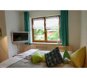 a bedroom with a bed with green curtains and a television at Bodenseenahe ruhige Ferienoase in Uhldingen-Mühlhofen