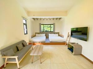 a living room with two beds and a tv at OceanSeeker in Green Island