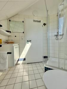 a white bathroom with a shower and a toilet at FeWo-Julius am Weser-Sandstrand in Berne +96 photos