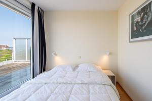 a bedroom with a bed and a large window at Penthouse Ostend with Seaview in Ostend