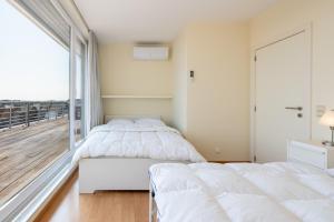 two beds in a bedroom with a balcony at Penthouse Ostend with Seaview in Ostend