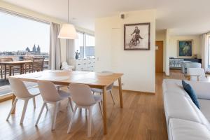 a dining room and living room with a table and chairs at Penthouse Ostend with Seaview in Ostend