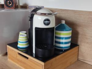 a coffee maker and a container on a wooden shelf at La Mansardina in Croviana