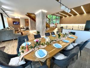 a dining room with a long wooden table and chairs at Casa River in Băişoara