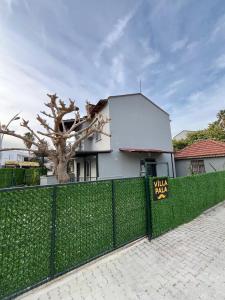 a fence with a sign in front of a white house at Villa PALA in Kemer