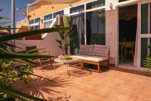 a patio with a couch and a table on a balcony at Casa Palmita Costa Calma in Costa Calma