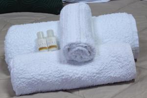 a pile of towels with two bottles on a bed at Appartamento Il Loftino in Forlì