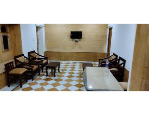 斋沙默尔Hotel Namaste jaiselmer inn, Jaiselmer的一间设有椅子和桌子的等候室以及一台电视 更多23张照片