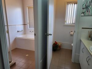 a bathroom with a bath tub and a sink at Goolwa Getaway in Goolwa +13 photos