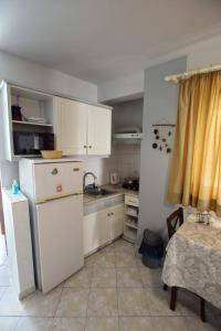 a kitchen with a white refrigerator and a table at Eleni's Summer Apartment in Tolo