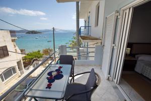 a table on a balcony with a view of the ocean at Eleni's Summer Apartment in Tolo