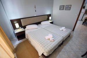 a bedroom with a bed with two towels on it at Eleni's Summer Apartment in Tolo +16 photos