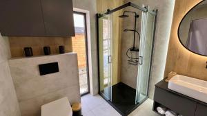 a bathroom with a shower and a sink and a mirror at Górska Przystań Sierpnica dom Duża Sówka in Sierpnica