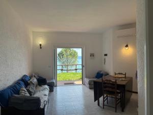 a living room with a blue couch and a table at Vista Mare in Porto Santo Stefano