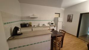 a small kitchen with a table and a microwave at Charmant t2 idéal Curiste 1min à pied de la cure thermale in Le Boulou