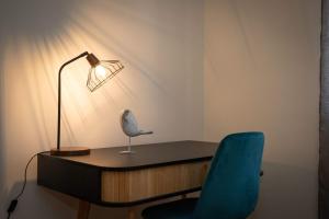 a desk with a lamp and a blue chair at Apartamento Janela do Atlantico in Machico