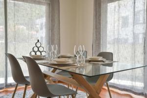 a dining room with a glass table and chairs at Apartamento Janela do Atlantico in Machico