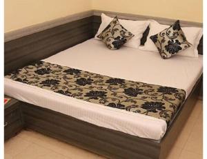 a bed with black and white pillows on it at Hotel heena plaza, mount abu in Mount Ābu +13 photos
