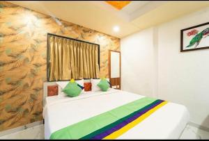 a bedroom with a large white bed with colorful pillows at Agy Hotels in Pune